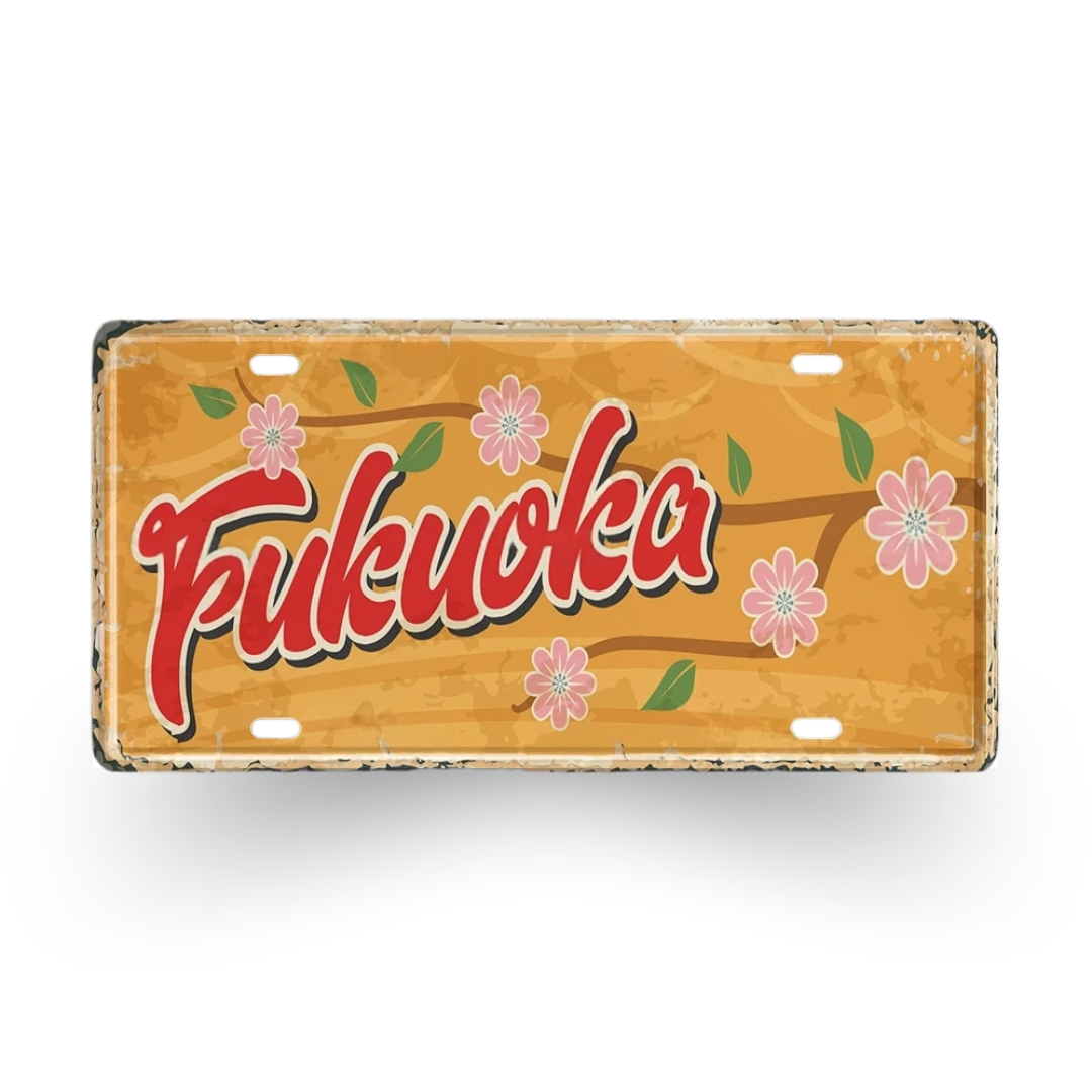 Decorative sign with 'Fukuoka' text and floral designs on a white background
