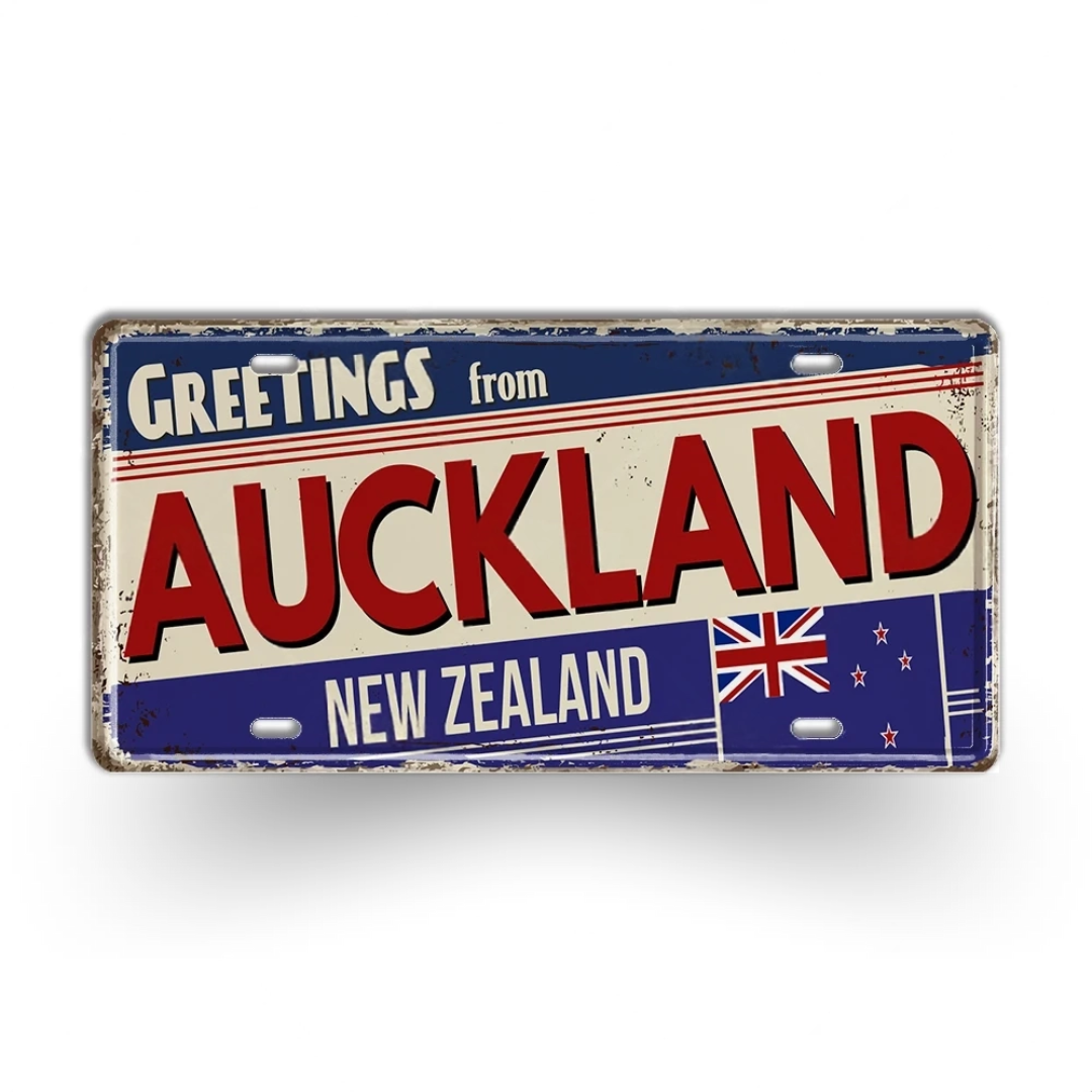 Vintage-style sign with 'Greetings from Auckland, New Zealand' text and New Zealand flag.