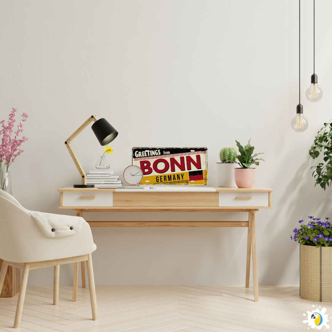 Modern home office with a desk, chair, and decorative items including a 'Greetings from Bonn, Germany' sign.