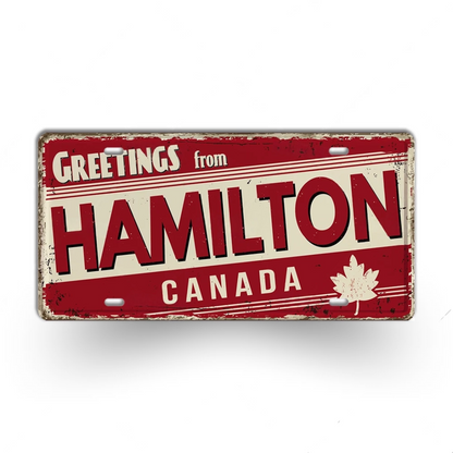 Vintage-style sign with 'Greetings from Hamilton, Canada' text on a red background