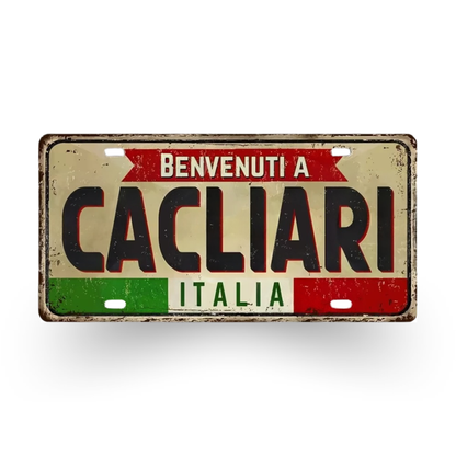 Vintage-style license plate with 'Benvenuti a Cacliarò Italia' text on a white background