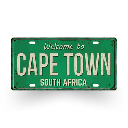 Green metal sign with 'Welcome to Cape Town, South Africa' text on a white background