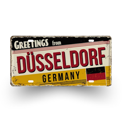 Vintage-style sign with 'Greetings from Düsseldorf, Germany' text and German flag design.