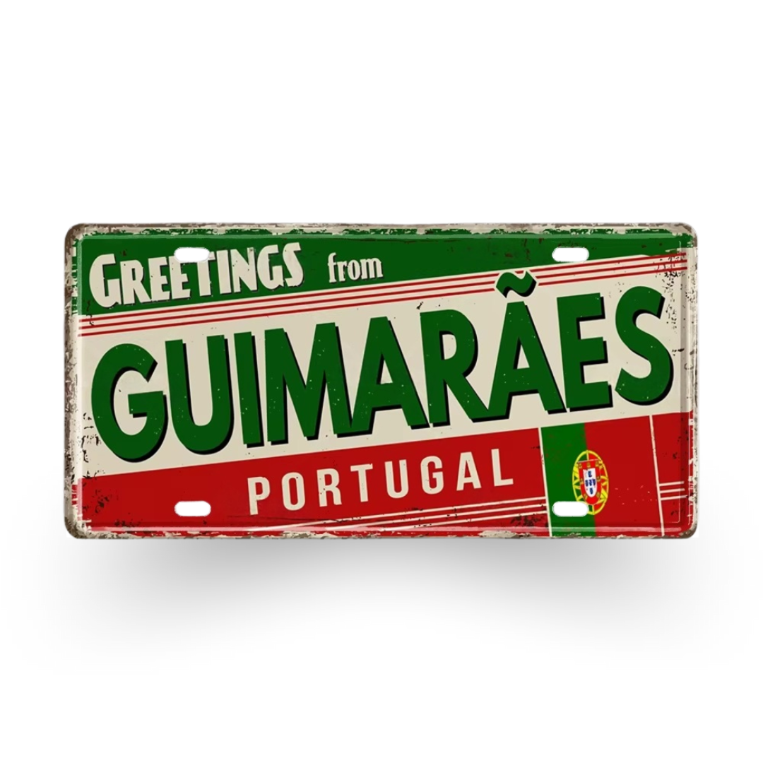Decorative sign with 'Greetings from Guimaraães Portugal' text on a white background