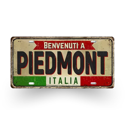 Vintage-style sign with 'Benvenuti a Piedmont Italia' text on a white background