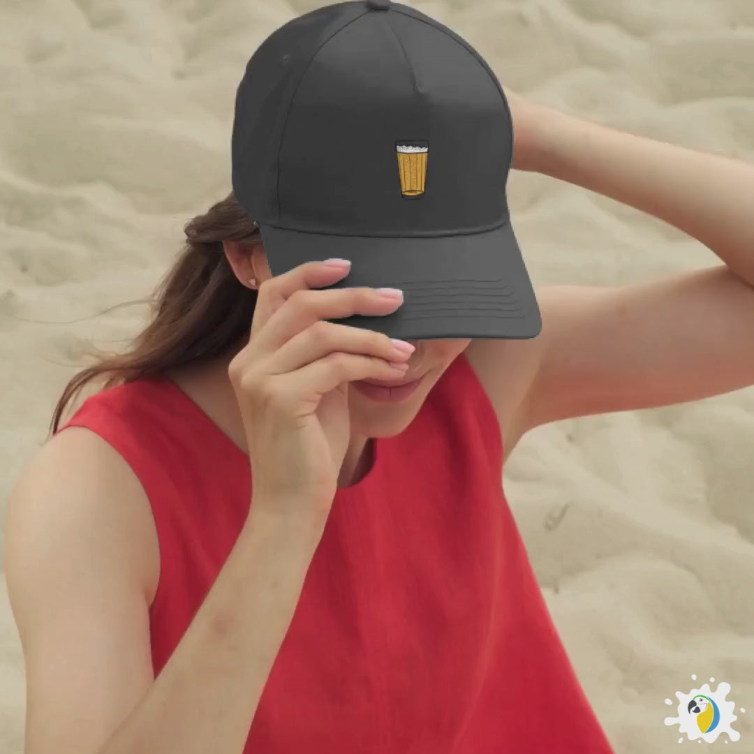 Papagaio Studio's Cervejinha Hat is displayed on a beach and balcony by two girls.