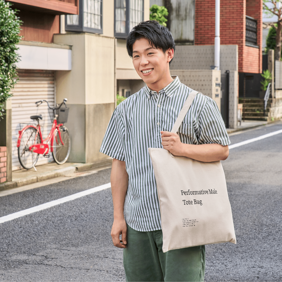 A stylish canvas tote bag featuring a self-aware aesthetic, designed for the modern male shopper. The bag showcases a unique performative design, blending functionality with contemporary art influences, perfect for carrying everyday essentials.