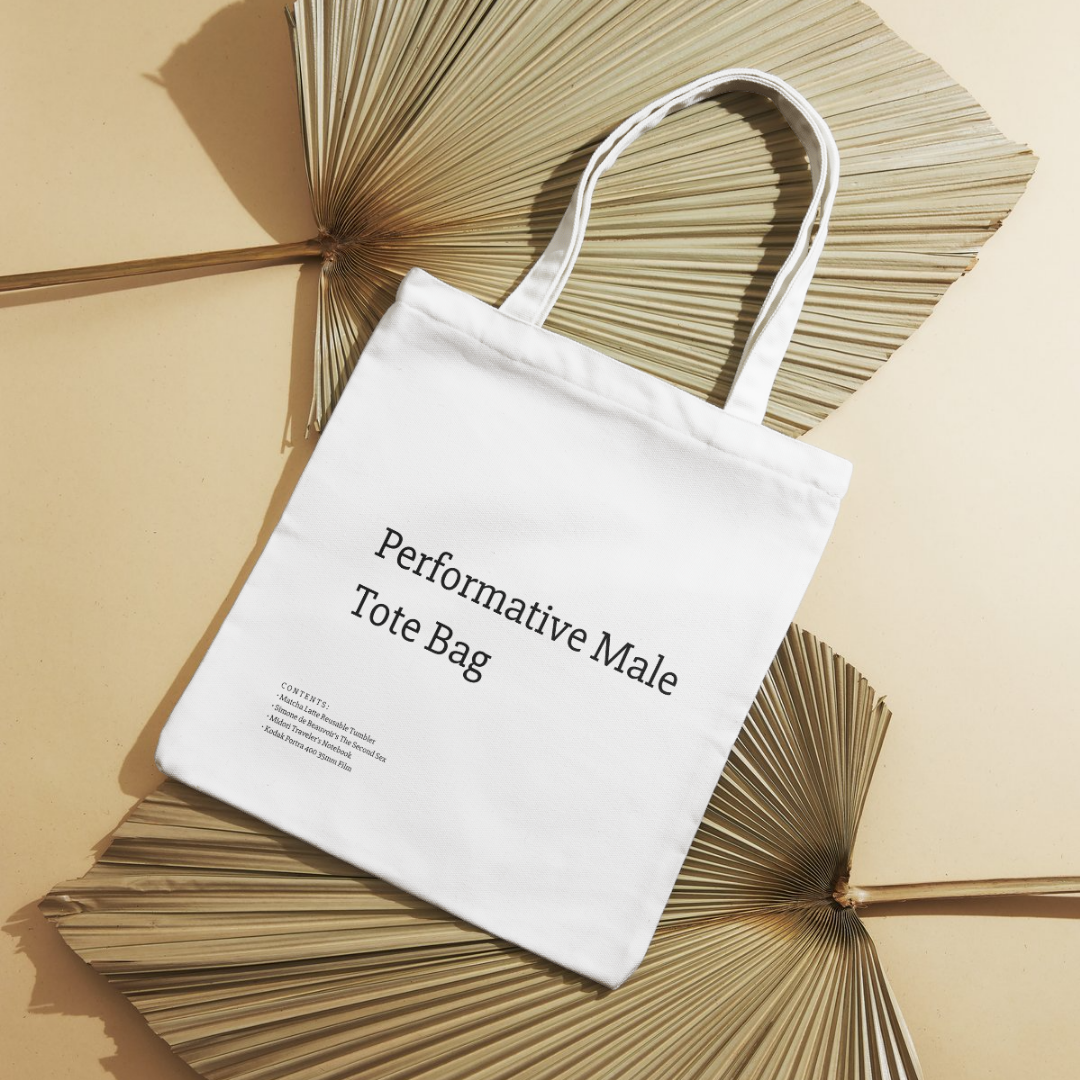 A stylish canvas tote bag featuring a self-aware aesthetic, designed for the modern male shopper. The bag showcases a unique performative design, blending functionality with contemporary art influences, perfect for carrying everyday essentials.